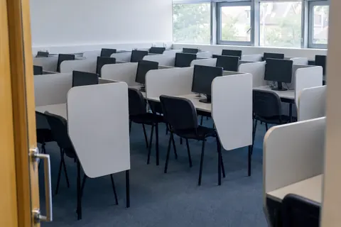 Bilgisayar istasyonları bulunan boş bir dil sınavı salonu